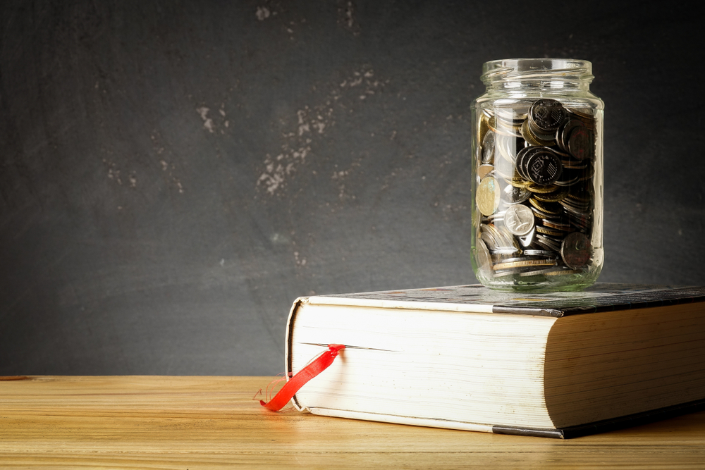 Image of money jar and book suggesting funding for education